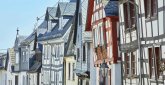 Historische Altstadt von Montabaur – Fachwerk und Schieferdächer Reihe eng stehender Häuser mit weißen und roten Fachwerkfassaden, schrägen Schieferdächern, kleinen Fenstern und dekorativen Details, Straßenlaterne im Vordergrund, blauer Himmel im Hintergrund