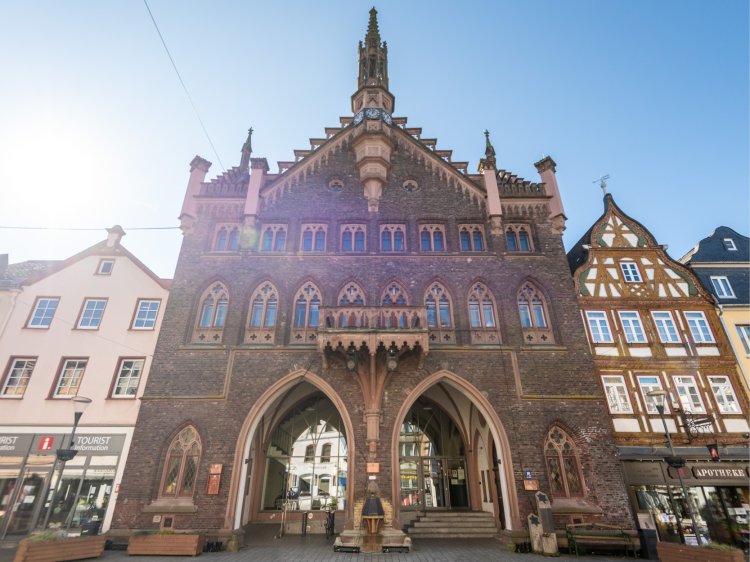 Historisches Rathaus in Montabaur – Kultur erleben in der Altstadt Historisches Rathaus in Montabaur – prächtige Fassade mit gotischen Spitzbögen und filigranen Verzierungen, flankiert von Fachwerkhäusern unter klarem blauem Himmel