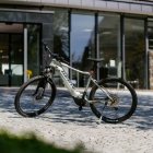 Weißes E-Bike der Marke Haibike steht auf einem gepflasterten Vorplatz vor dem modernen Eingangsbereich des Hotels Schloss Montabaur, umgeben von Glasfassade und Natursteinmauer