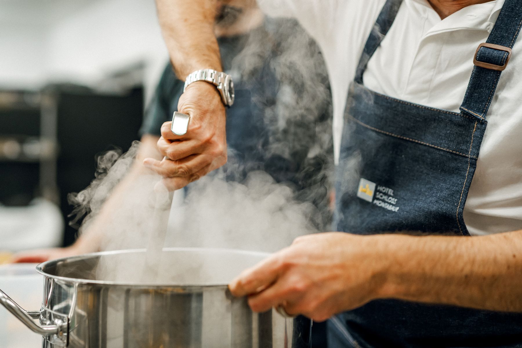 Kochkurs im Schloss Montabaur Teilnehmerinnen und Teilnehmer bereiten gemeinsam frische Zutaten an Kochstationen zu – in einer modernen Küche im Hotel Schloss Montabaur.