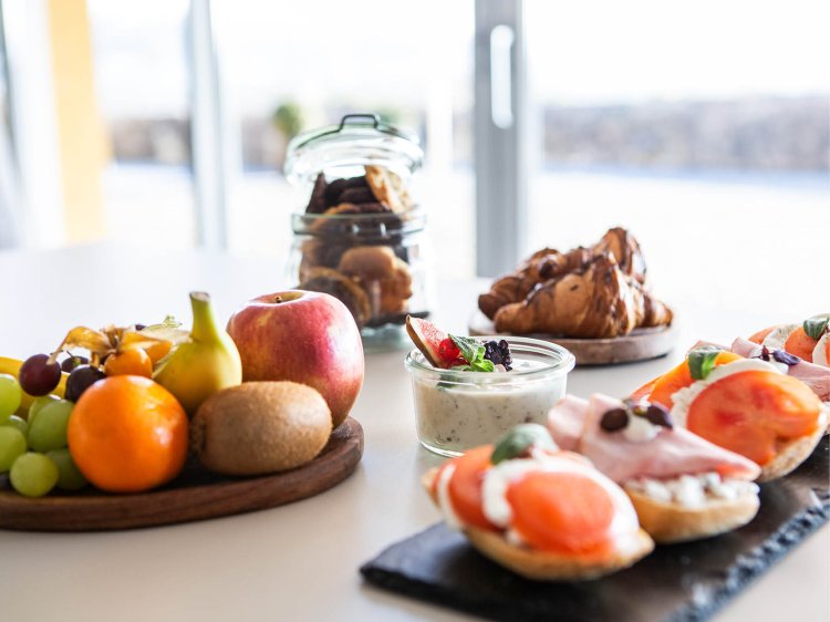 Edles Buffet mit kleinen Häppchen, Törtchen, Barista-Kaffeespezialitäten und frisch gepresstem Saft auf einem elegant gedeckten Tisch im Schloss Montabaur.