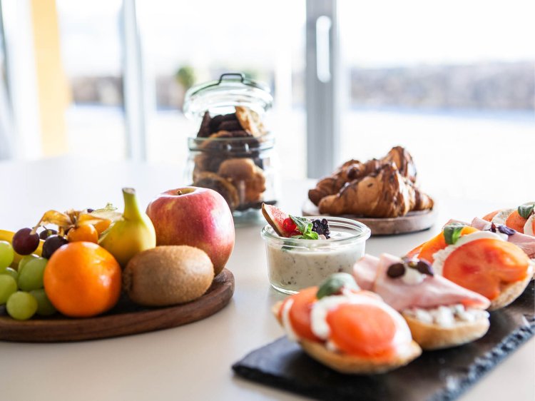 Premium Break with Gourmet Highlights Elegant buffet with gourmet bites, pastries, barista coffee specialties, and freshly squeezed juice on a beautifully set table at Schloss Montabaur.