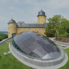 Außenansicht des Veranstaltungszentrums Schloss Montabaur mit Glasfassade, Eingangsbereich und gepflegtem Vorplatz.