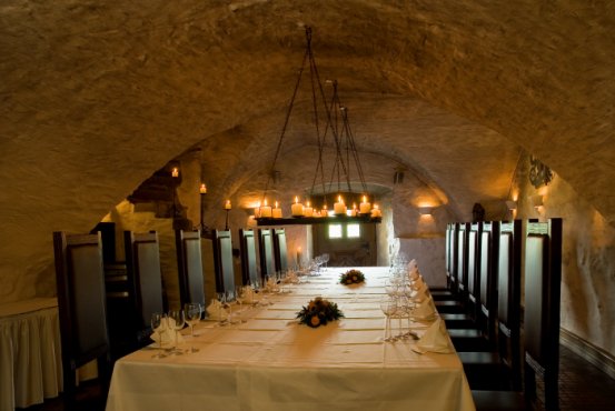 Atmospherically lit vaulted cellar in Hotel Schloss Montabaur with a festively laid table for up to 18 guests