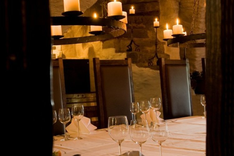 Atmospherically lit vaulted cellar in Hotel Schloss Montabaur with a festively laid table for up to 18 guests