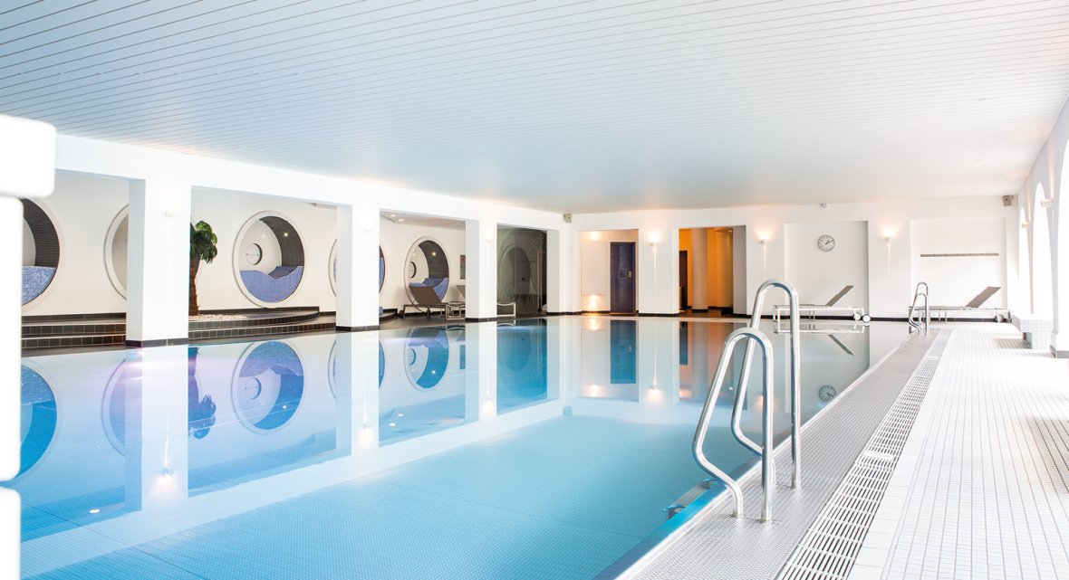 Modern spa pool area at Montabaur Castle Hotel featuring clear water and elegant loungers.
