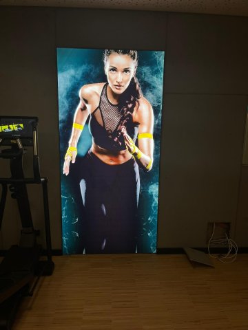 Fitnessbereich – Hotel Schloss Montabaur Stilvoller Fitnessbereich im Hotel Schloss Montabaur mit großem Motivposter und modernen Trainingsgeräten.