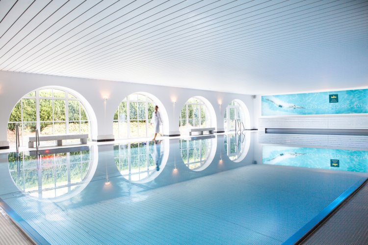 Innenpool Spa – Hotel Schloss Montabaur Moderner Innenpool im Spa des Hotels Schloss Montabaur mit großen Rundbogenfenstern und entspannender Atmosphäre.