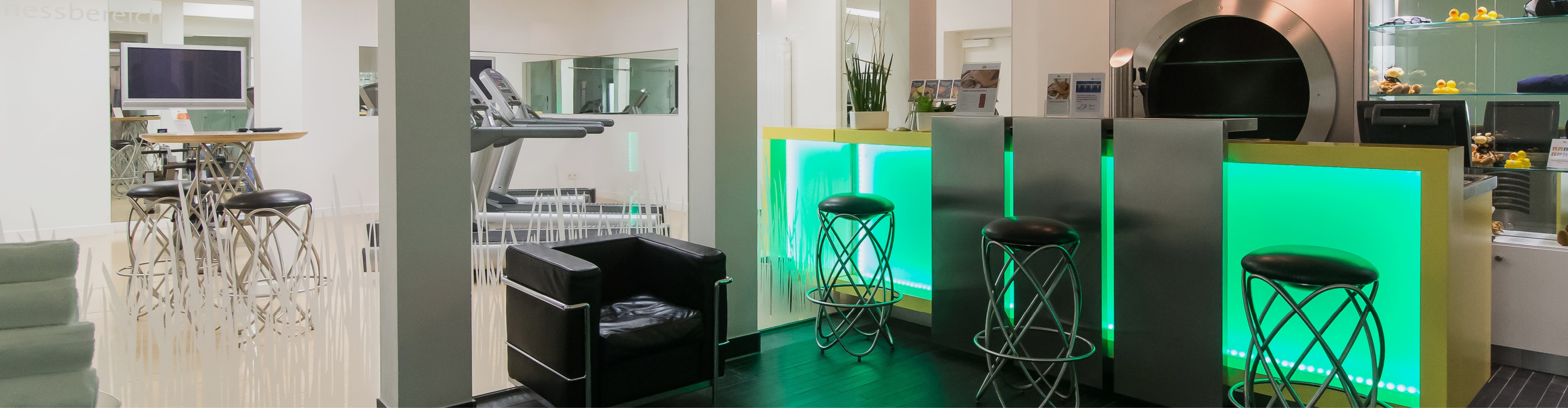 Fitness lounge at Montabaur Castle Hotel with seating and view of the workout zone.