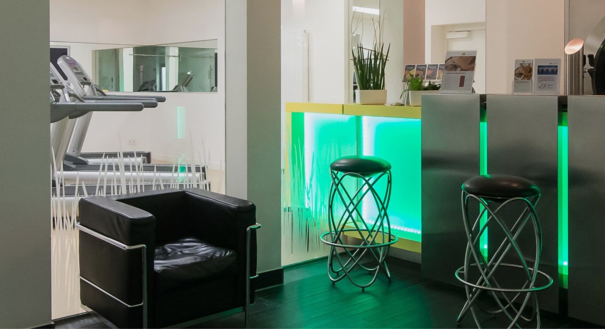Fitness lounge at Montabaur Castle Hotel with seating and view of the workout zone.