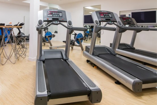 Treadmill zone at Montabaur Castle Hotel fitness studio featuring three modern machines in a bright setting.