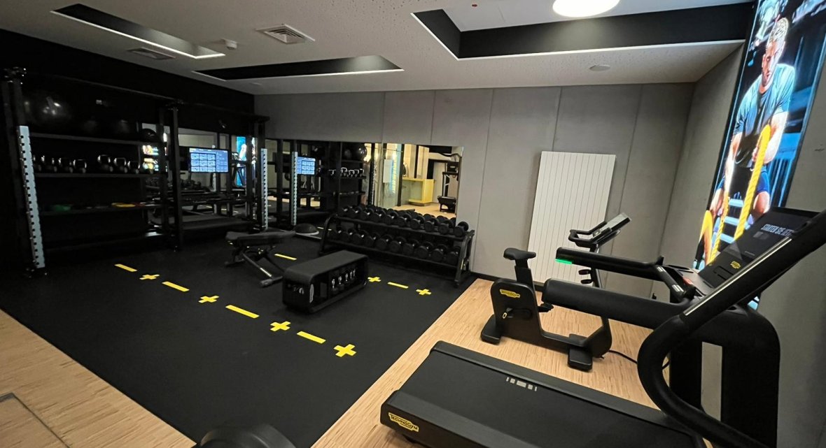 Fitnessstudio im Hotel Schloss Montabaur mit Laufbändern, Hanteln, Spiegelwand und motivierendem Poster.