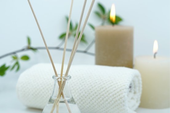 Wellness Accessories – Montabaur Castle Hotel Wellness setup at Montabaur Castle Hotel Spa featuring reed diffuser, candles, towel, and green accents.