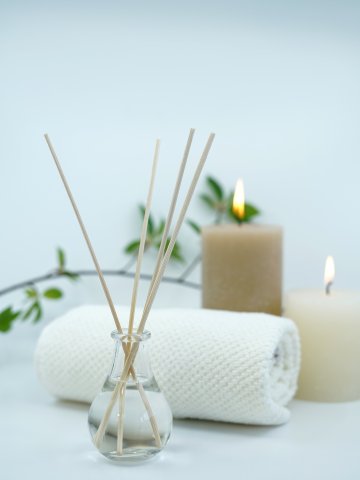 Wellness-Arrangement im Spa des Hotels Schloss Montabaur mit Duftstäbchen, Kerzen und Handtuch für entspannte Atmosphäre.