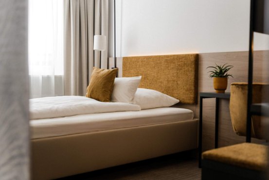 Economy Plus Zimmer mit Schreibtisch, Bett und gemütlicher Sitzgelegenheit im Hotel Schloss Montabaur